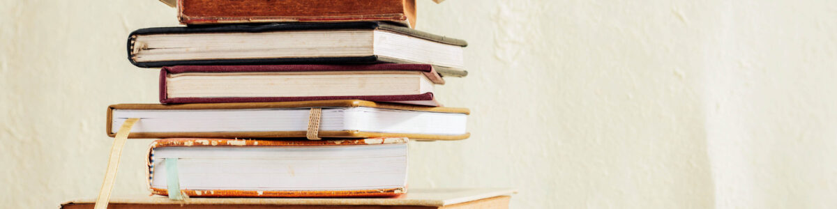 Old book stack on a wooden floor.
